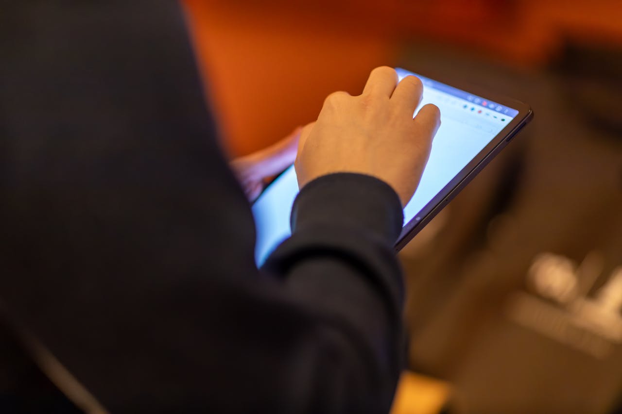 about-01 Close-up of a person using a tablet, showcasing technology and modern lifestyle.