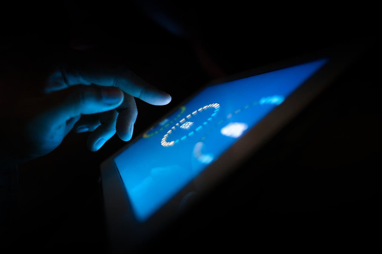 services-01 Close-up of a hand interacting with a glowing touchscreen in a dark setting, highlighting technology use.